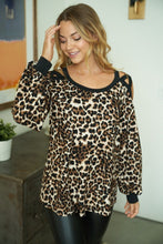 A long sleeve leopard print knit top with a round neck featuring a puff sleeve and a cut out detail.