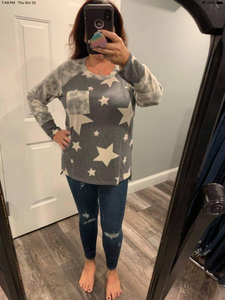 PLUS Long sleeve star print knit top with a round neck featuring a tie dye patch pocket, tie dye trim, and a side slit - Grey or Taupe