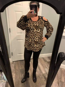 A long sleeve leopard print knit top with a round neck featuring a puff sleeve and a cut out detail.