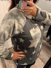 Long sleeve star print knit top with a round neck featuring a tie dye patch pocket, tie dye trim, and a side slit - Grey or Taupe